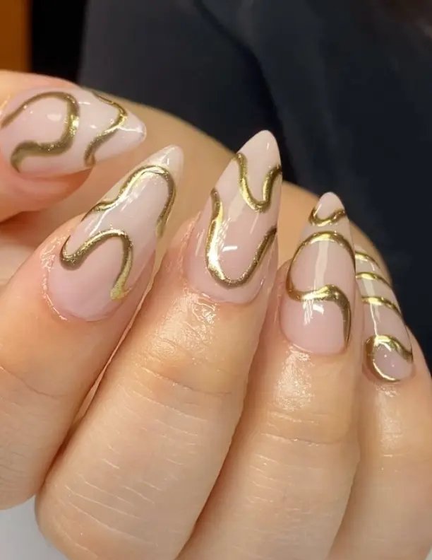 Milky white stiletto nails with gold chrome swirls
