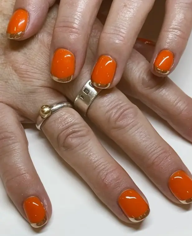 Tangerine orange nails with gold chrome tips
